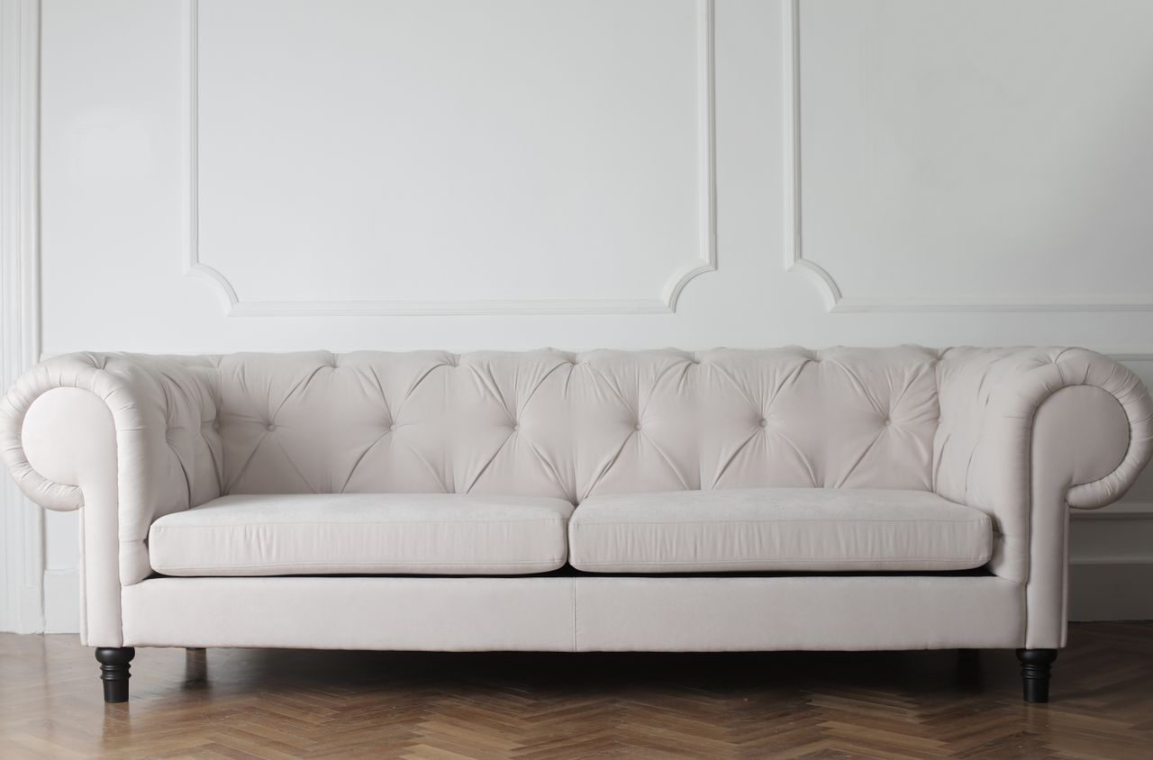 Canapé blanc luxueux dans un intérieur moderne et minimaliste avec un parquet en bois.